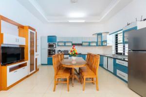 a kitchen with a table and chairs and a refrigerator at Kegotel Villa Bãi Sau ngay Tháp Tam Thắng in Vung Tau