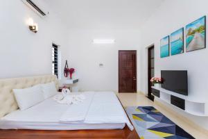 a bedroom with a bed and a flat screen tv at Kegotel Villa Bãi Sau ngay Tháp Tam Thắng in Vung Tau +3 photos