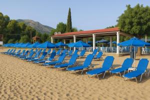 a row of blue chairs and umbrellas on a beach at KALIVAKI in Georgioupolis