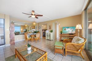 un soggiorno con tavolo e sedie e una cucina di Nohonani 103 a Kahana