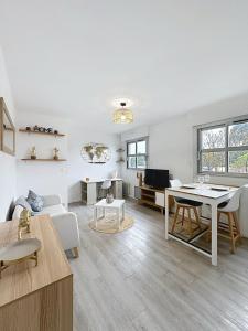 a white living room with a table and chairs at Appartement 2 personnes - Stade rugby Yves du Manoir in Montpellier