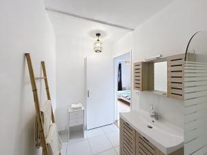 a white bathroom with a sink and a mirror at Appartement 2 personnes - Stade rugby Yves du Manoir in Montpellier +19 photos