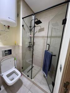a bathroom with a toilet and a glass shower at Ocean park zenata in Aïn Harrouda +5 photos