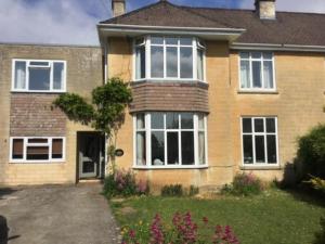 a brick house with white windows and a driveway at Home for one! in Midford