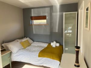 a bedroom with a bed with a yellow blanket at Home for one! in Midford
