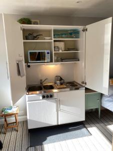a small kitchen with a sink and a stove at Home for one! in Midford