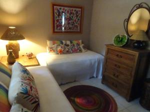 ein Schlafzimmer mit einem Bett und eine Kommode mit einer Lampe in der Unterkunft Beautiful Casita at La Madera Beach, Zihuantanejo in Zihuatanejo + 26 Fotos