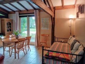 a bedroom with a bed and a table and a dining room at Quatre Saisons Été in Bergerac