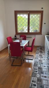 a dining room with a table and red chairs at Villa Domus Roma in Rome