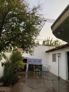 Villa NuevaにあるMendoza Alquiler Temporarioの建物の前の椅子とテーブルのあるパティオ