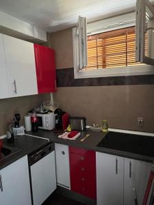 アルメリアにあるAcantilado del marのキッチン(赤と白のキャビネット付)、窓