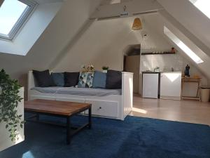 un salon avec un canapé et une table dans l'établissement 4 minutes from Sainte-Mère-Église - Independent apartment on first floor of big house with garden and heated pool opened if weather is ok, à Fresville
