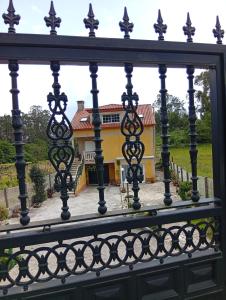 a fence with a house in the background at Villa Merchy Combarro in Poio