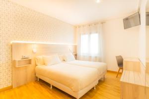 Łóżko lub łóżka w pokoju w obiekcie Hostal Gran Duque