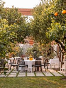 a table and chairs in a garden with oranges at Boutique Hotel Casa Mariantonia in Anacapri