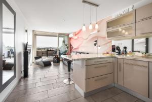 a kitchen with a counter and a dining room at Village Naturiste R4N - Sixty9 Port Ambonne in Cap d'Agde +11 photos