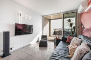 a living room with a couch and a tv at Village Naturiste R4N - Sixty9 Port Ambonne in Cap d'Agde