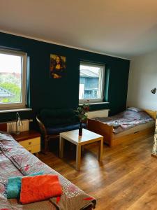 a room with two beds and a couch and a table at Sloneczny pokoj in Świnoujście