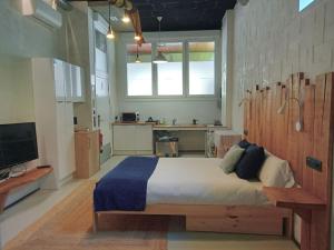 a bedroom with a large bed and a kitchen at Itsaso Apartamentuak in Getaria
