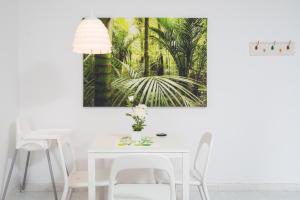 a white dining room with a white table and chairs at Apartamento Hércules in Costa Del Silencio
