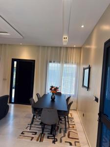 een eetkamer met een zwarte tafel en stoelen bij Les Résidences KYM in Yamoussoukro