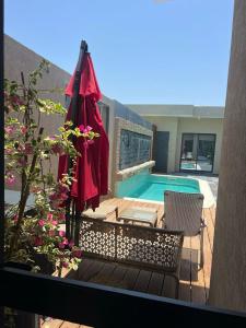 een patio met een parasol en een zwembad bij Les Résidences KYM in Yamoussoukro