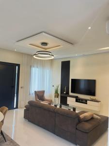 een woonkamer met een bank en een flatscreen-tv bij Les Résidences KYM in Yamoussoukro