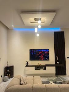 een woonkamer met een bank en een flatscreen-tv bij Les Résidences KYM in Yamoussoukro +5 foto's