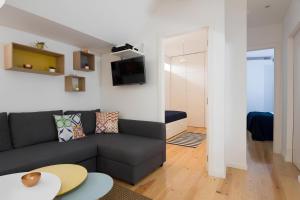 een woonkamer met een bank en een tafel bij Casa do Castelo 1- Work or Relax in the Historic heart of Lisbon! in Lissabon