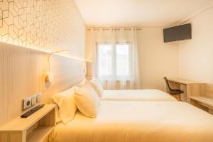Łóżko lub łóżka w pokoju w obiekcie Hostal Gran Duque