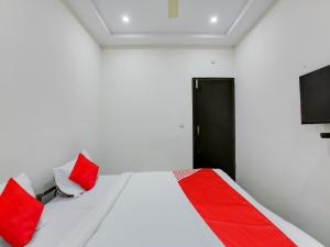 a bedroom with a bed with red and white pillows at Hotel O Manjushree Boarding & Lodging nearby Dr.BR Ambedkar Stadium Basveshwar nagar in Bengaluru +24 photos