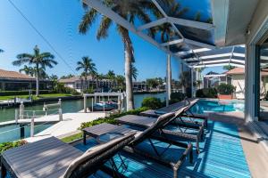 a swimming pool with chaise lounges on a house at New Listing! Updated & Waterfront I Walk to Beach in Marco Island
