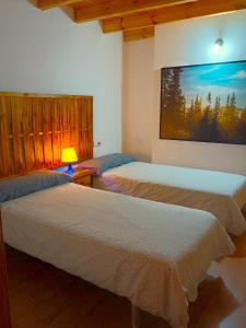 two beds in a room with a picture on the wall at A Casa da Boa Xente VUT-OU-1329 in Verín