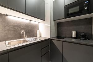 a kitchen with a sink and a microwave at Apartments Kozmo Residences Budapest in Budapest