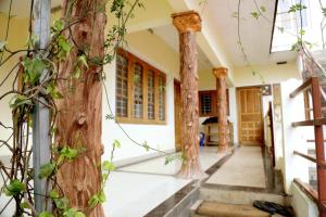 un couloir d'une maison avec des colonnes et des arbres dans l'établissement Aathi cottage, à Chinnakanal