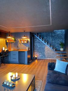 a living room with a couch and a kitchen and a staircase at WOODLİFE BUNGALOv in Rize