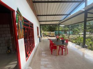 a patio with a wooden table and red chairs at Cabaña jaguar Jacuzzi in Pepino