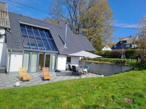a house with a patio with chairs and tables at Haus Burg, Ferienhaus in Bongard