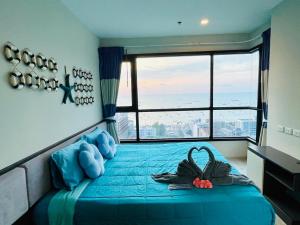 a bedroom with a blue bed with a large window at The base Central 2 bed 1 bath 514 by Numam in Pattaya +48 photos