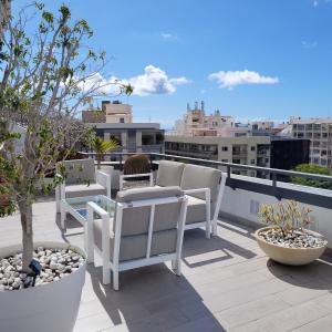 a woman sitting in chairs on a balcony at Sky Santa Cruz Penthouse in Santa Cruz de Tenerife