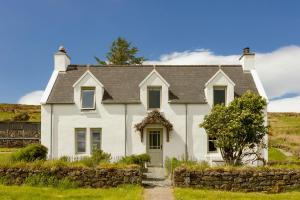 una casa bianca con un muro di pietra di Mint Croft Luxury Self-Catering Cottages a Geary