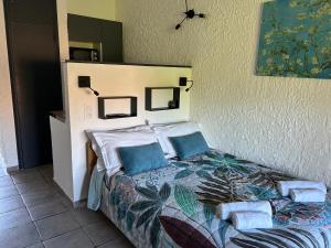 a bedroom with a bed with blue pillows at Le Clos des Arbousiers in Linguizzetta