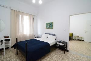 a bedroom with a large bed with a blue blanket at The SPiTi Project 33 in Kavala