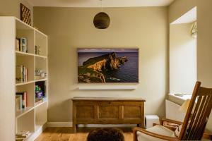 un soggiorno con TV appesa al muro di Mint Croft Luxury Self-Catering Cottages a Geary
