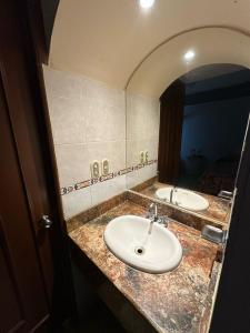 a bathroom with two sinks and a mirror at Hotel Impala Veracruz in Veracruz +46 photos
