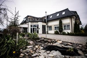 ein großes weißes Haus mit einem Steinhof in der Unterkunft Pensjonat Augustyniak in Ostrołęka