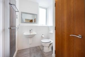 a white bathroom with a toilet and a sink at Western Apartments Excel in London +71 photos