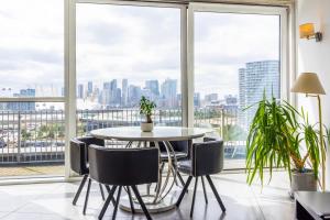 a table and chairs in a room with a large window at Western Apartments Excel in London
