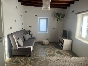 a living room with a couch and a tv at A casa d’ Irene in Kampos Paros
