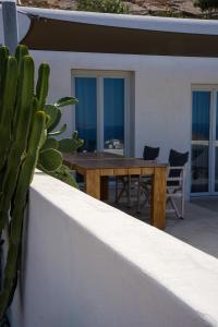 a wooden table on a patio with a cactus at Wabi Luxury Suites & Maisonettes Ios in Ios Chora